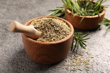 Bowls with fresh and dry rosemary on grey table