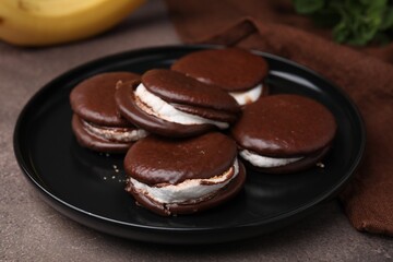 Tasty sweet choco pies on brown table, closeup