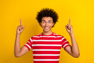 Portrait of youngster dude guy direct up fingers empty space shop poster wear shirt pants isolated yellow color background