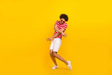 Fototapeta na wymiar Full length photo of cheerful positive guy dressed red t-shirt dark glasses having fun dancing isolated yellow color background