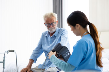 blood pressure gauge. Professional caregiver nursing visit elderly patient at home. Nurse assisting senior patient at nursing home.