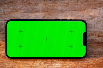 Smart phone with green screen on wood table