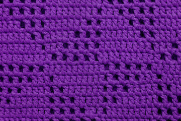 Crochet purple mesh fabric with triangle pattern. Knitted background.