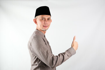 Obraz na płótnie Canvas Portrait of Asian Moslem Man doing positive gesture with hand, thumbs up, ok sign 