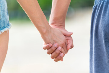 Close up couple lovers hold hands in outdoors background