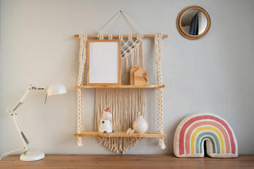 Mockup of a wooden frame in a modern interior. Beautiful macrame shelf in the room.
