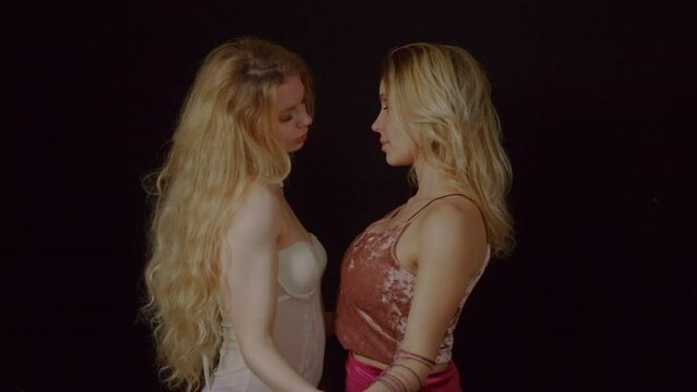 A portait of a blonde young couple of lovers flirting and touching each others. A sight of understanding is the beginning for taking hands of the partner and approaching creating a sensual alchemy