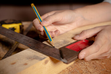 Female hands using a try square to check that the woodworking corners are square with a set collection of working hand tools for the wooden, Toolset with the do it yourself (DIY)in wood studio - obrazy, fototapety, plakaty