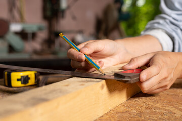 Female hands using a try square to check that the woodworking corners are square with a set collection of working hand tools for the wooden, Toolset with the do it yourself (DIY)in wood studio