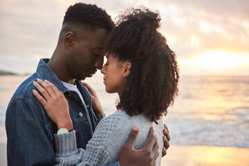 Affectionate multiethnic couple standing with closed eyes on a beach at dusk - Powered by Adobe