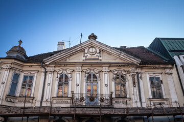 Obraz premium Detail of an old ruined balcony on an abandoned derelict building in the center of Belgrade, Serbia, waiting for reconstruction in an urban renovation project.