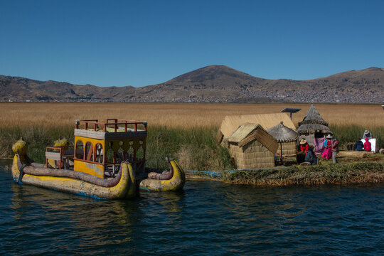 Island of the uros, native families working in tourism, uros boat on Lake Titicaca, with views of the mountains. 