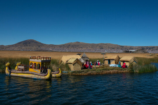 Floating island of Uros, with views of Lake Titicaca and a typical Uros boat, built with totora reeds, in Puno, Peru.