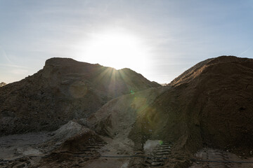 Mountain landscape/ gravel pit.. Sand, rocks and sun at sunset time.
