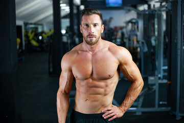 Fototapeta na wymiar Strong sexy muscular bodybuilder guy in a gym. Concept clouseup,gym, crossfit, bodybuilding.