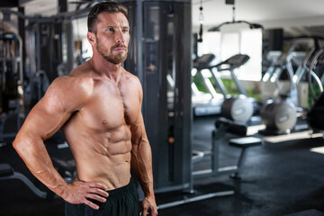 Naklejka na ściany i meble Strong sexy muscular bodybuilder guy standing ,gym, crossfit, bodybuilding.