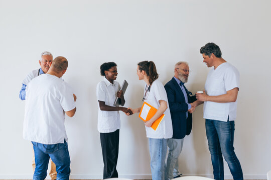 Doctors from a Medical Center Meet in the Meeting Room Exchanging Greetings - Powered by Adobe