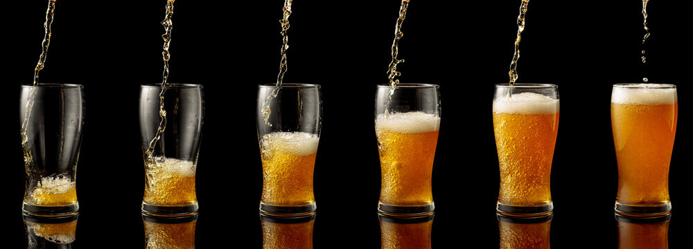 Pouring beer into a glass on a black background.