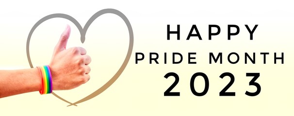 Hands which wear rainbow wristbands around with heart drawing and texts 'Happy Pride Month 2023' on...