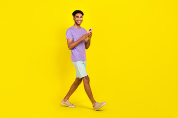 Fototapeta na wymiar Full body photo of young blogger man go with apple smartphone messenger app influencer social media repost isolated on yellow background
