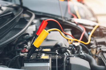 Fototapeta premium Using jumper wires to charge a car battery that has been discharged with electricity