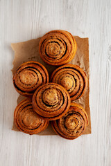 Homemade Cinnamon Roll Pastry on a white wooden background, top view. Flat lay, overhead, from above.