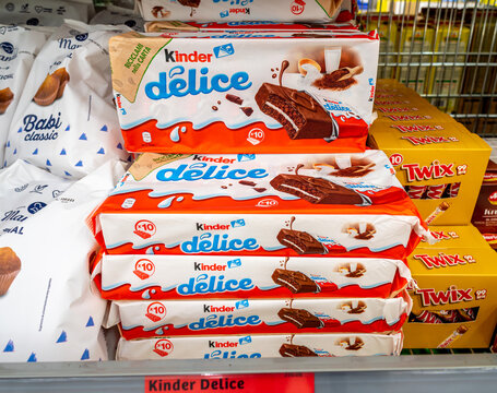 Italy - may 31, 2023: Kinder Delice snacks in 10-piece recyclable paper packaging next to packs of Twix chocolate bars for sale on the shelves of an Italian supermarket