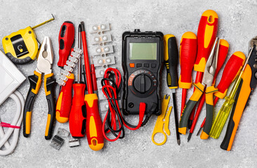 Electrician equipment on marble background with copy space.Top view.Electrician tool set.Multimeter, tester,screwdrivers,cutters,duct tape,lamps,tape measure and wires.Flet lay. © Avocado_studio