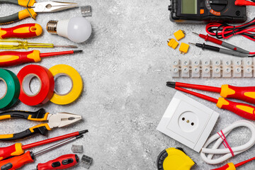 Electrician equipment on marble background with copy space.Top view.Electrician tool set.Multimeter, tester,screwdrivers,cutters,duct tape,lamps,tape measure and wires.Flet lay. © Avocado_studio