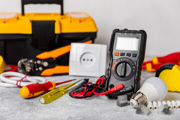 Electrician equipment on marble background with copy space.Top view.Electrician tool set.Multimeter, tester,screwdrivers,cutters,duct tape,lamps,tape measure and wires.Flet lay. © Avocado_studio