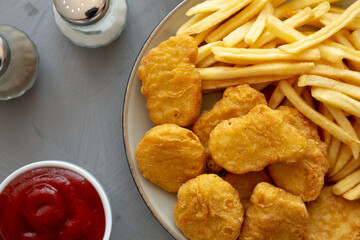 Homemade Chicken Nuggets and French Fries with Ketchup on gray background, top view. Flat lay, overhead, from above. Close-up.
