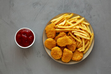 Homemade Chicken Nuggets and French Fries with Ketchup on gray background, top view. Flat lay, overhead, from above.