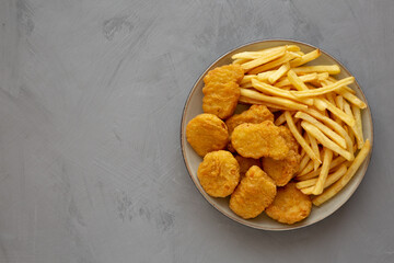 Homemade Chicken Nuggets and French Fries with Ketchup on gray background, top view. Flat lay, overhead, from above. Copy space.