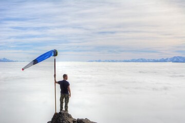 Photo of a man triumphantly waving the Argentine flag atop a majestic mountain in Bariloche