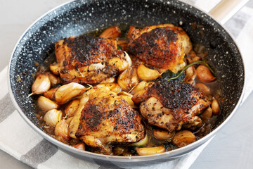 Homemade Chicken With 40 Cloves of Garlic on a Plate, side view.