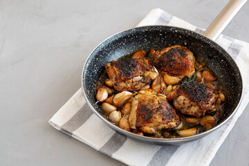Homemade Chicken With 40 Cloves of Garlic on a Plate, side view. Copy space.