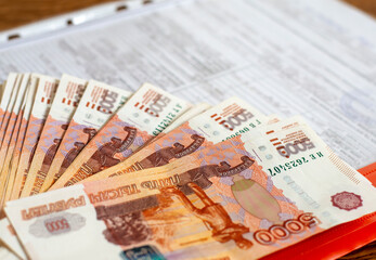 Banknotes of Russia 5000 rubles and a folder with documents. The concept of finance, investment, savings and cash.