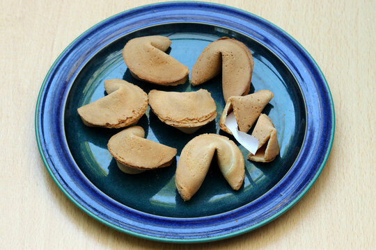 A selection of fortune cookies, one has been opened.