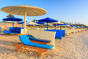 Obraz na płótnie Canvas Sun loungers with umbrellas on the beach in Marsa Alam at sunrise, Egypt