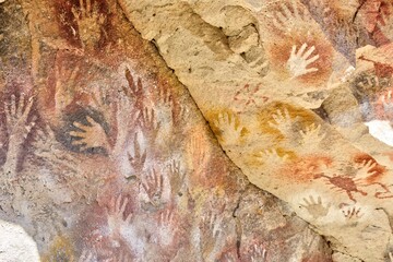 Photo of handprints on a rock wall in Cueva de las Manos, Argentina
