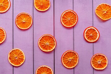 dried orange slices lie on a purple background