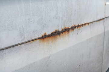 an old dirty beige car with terrible corrosion at the junction of two body panels. Illustration of the need for car body repair
