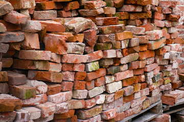 restoration work. the wall of the old building was dismantled. old moldy bricks lie on wooden pallets