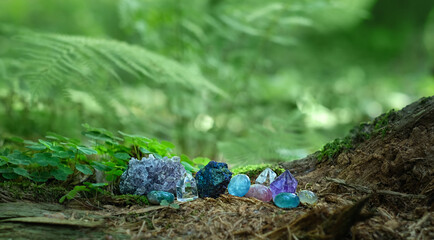 set of different minerals on natural dark forest background. Gemstones for healing Magic Crystal...