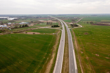 Drone photography of highway in rural setting surrounded by agricultural fields