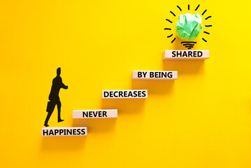 Happiness symbol. Concept words Happiness never decreases by being shared on wooden block. Beautiful yellow table yellow background. Businessman icon. Motivational Happiness concept. Copy space.