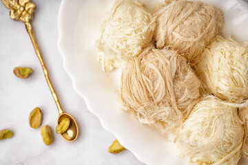 Plate with tasty Turkish Pismaniye on light background, closeup