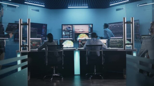 Team watch successful space rocket launch on big digital screens in mission control center. Diverse flight control workers in front of computers monitor crewed mission. Scientific space exploration.