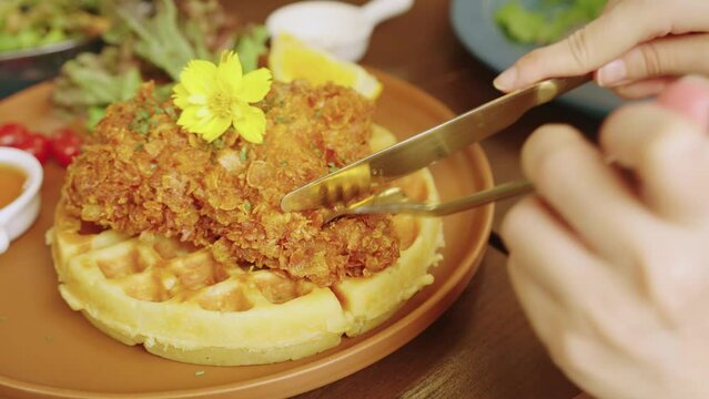 4k video, homemade fried chicken waffle with tomato, lemon and salad served with honey or maple syrup. breakfast, Breaded chicken on waffles with butter and syrup