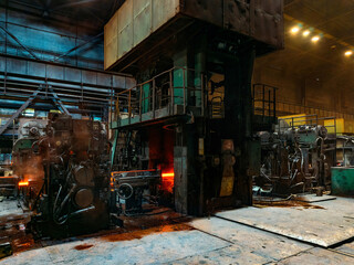 Fototapeta premium Rolled metal factory hot steel bar on conveyor moving through rollers
